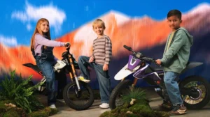 A small, sleek electric dirt bike for kids in purple with knobby tires and a high front fender.